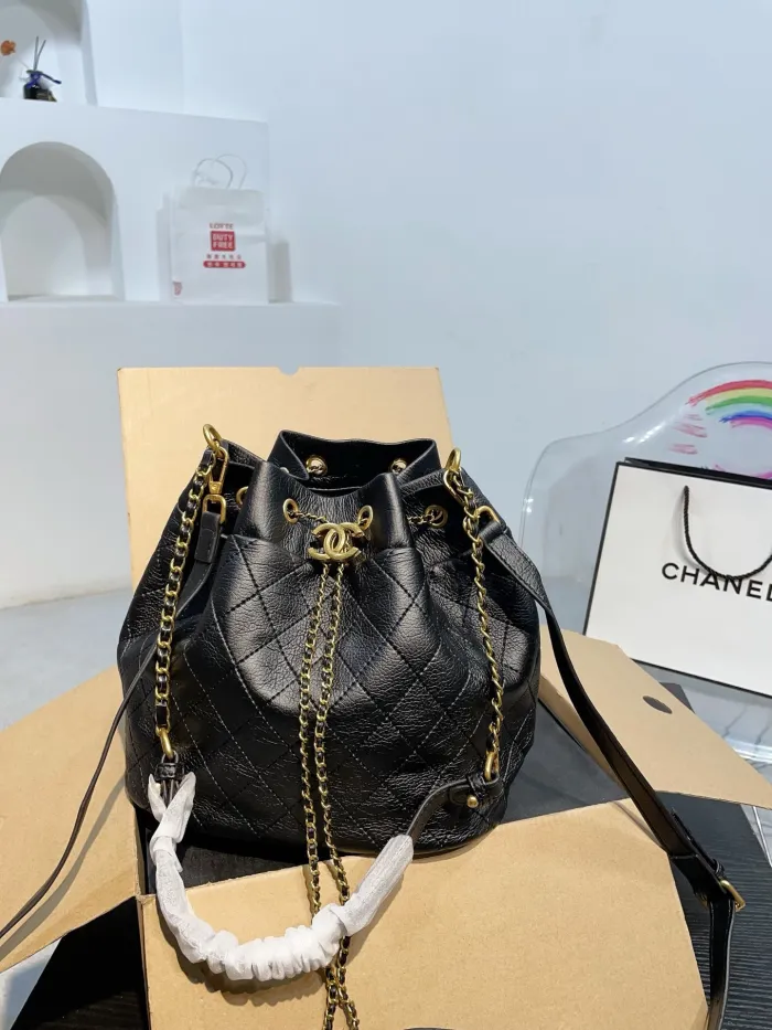 The Chanel bucket bag features a soft leather body and a shoulder strap, exuding a casual and elegant scent