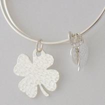 A wire bracelet with one big metal charms and two small charms