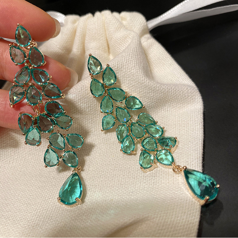 aretes de verde esmeralda en forma de hoja y oro laminado para alfombra roja