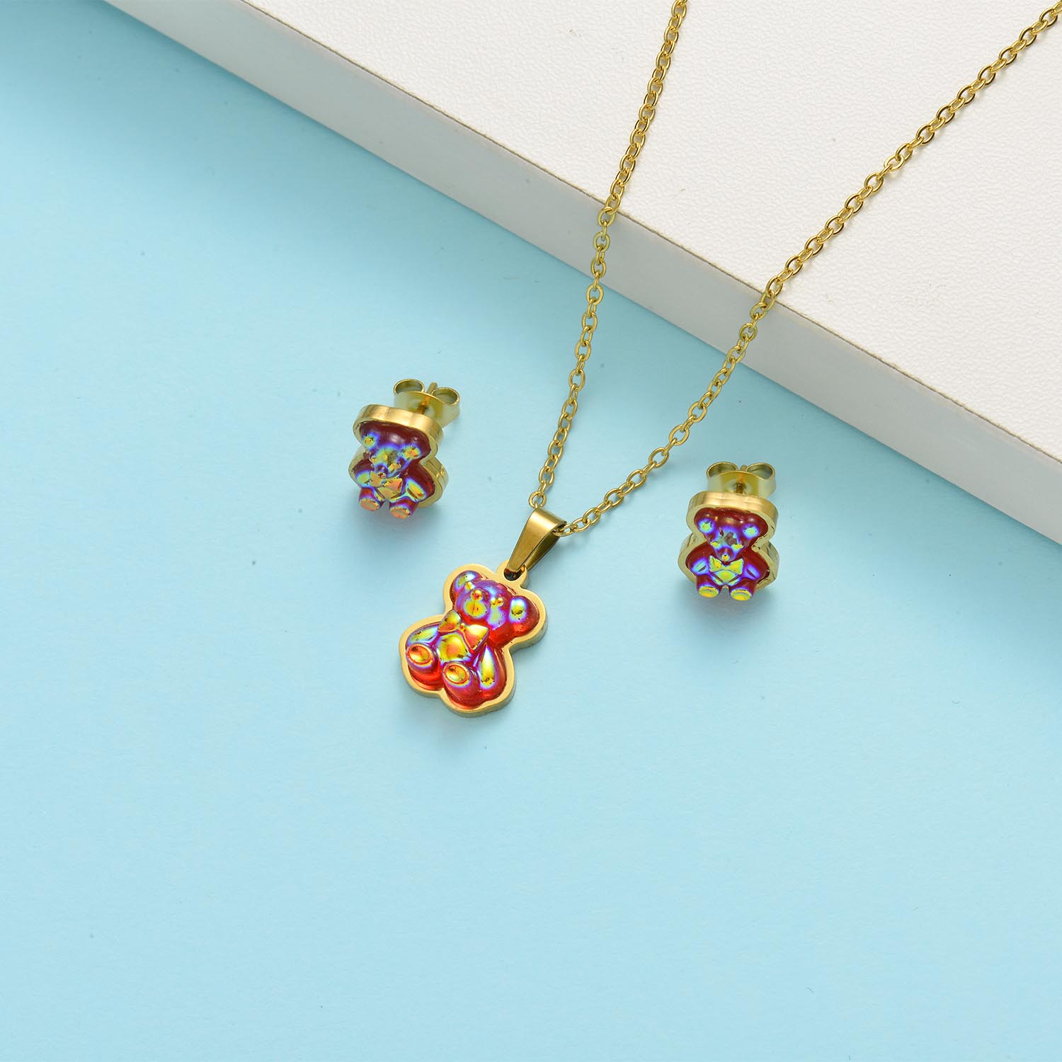 conjunto con arete para playa con dije de osito rojo color dorado