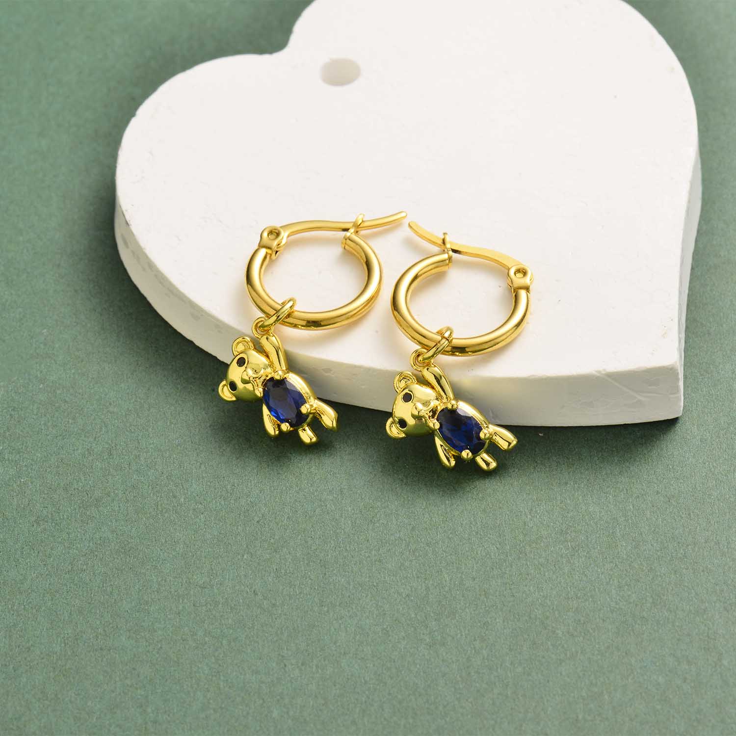 aretes de mujer en acero dorado con osito de piedra azul