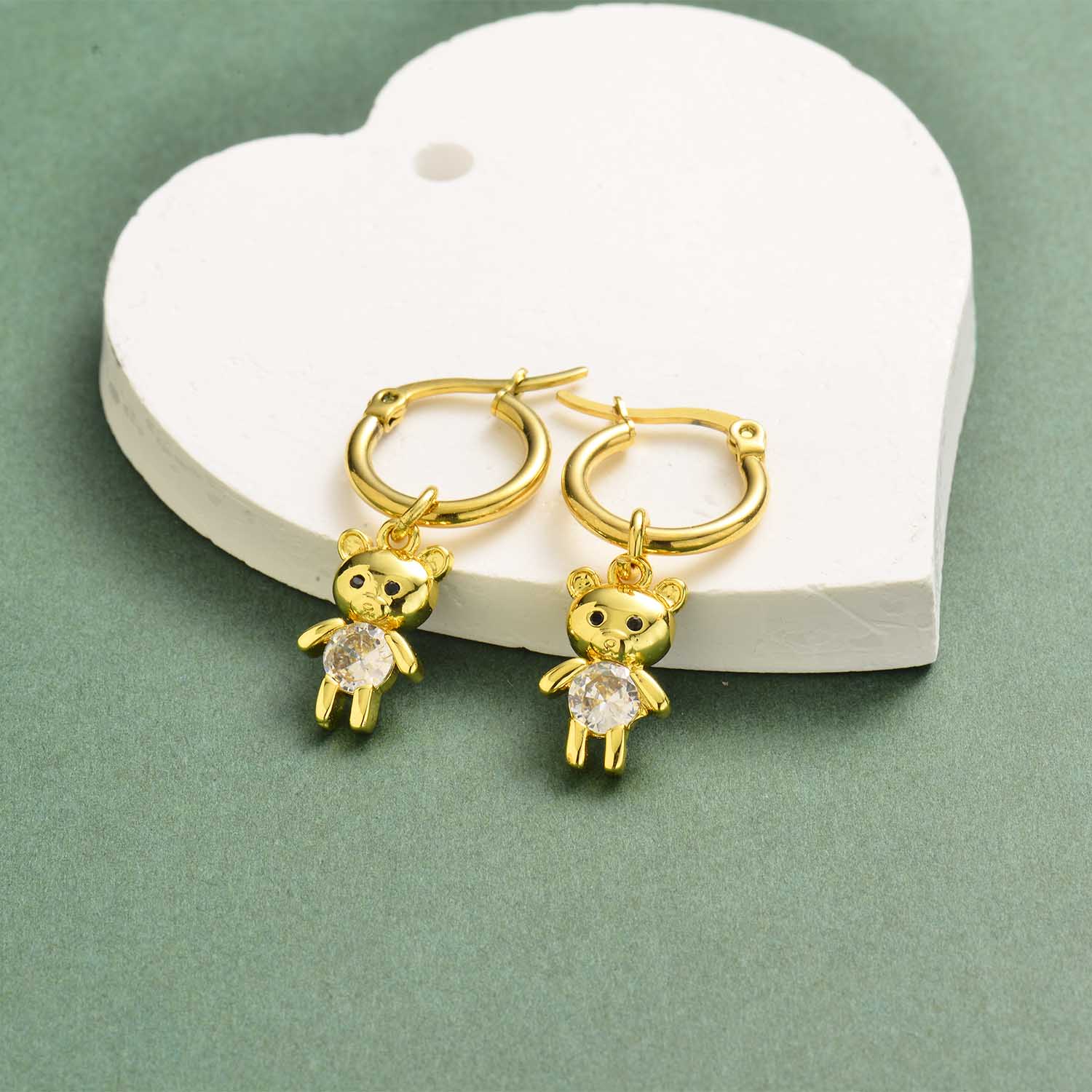 aretes de mujer en acero dorado con osito de piedra blanca