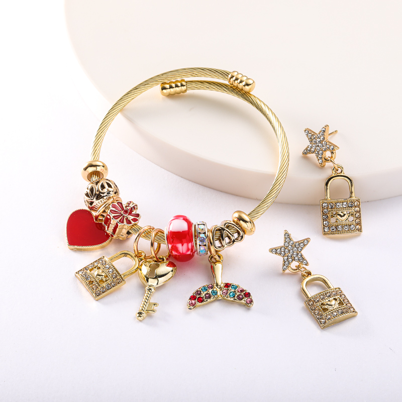 pulsera dorada con charms y aretes de candado y estrella