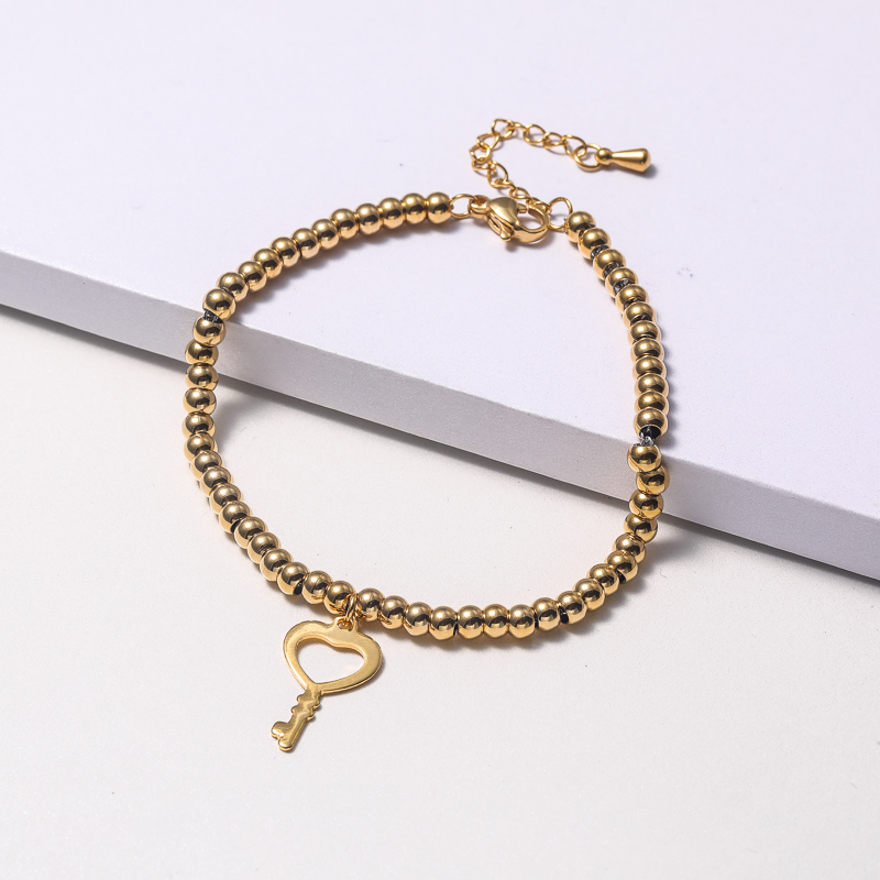 pulsera de moda dorada de bolita con dije forma de llave al por mayor