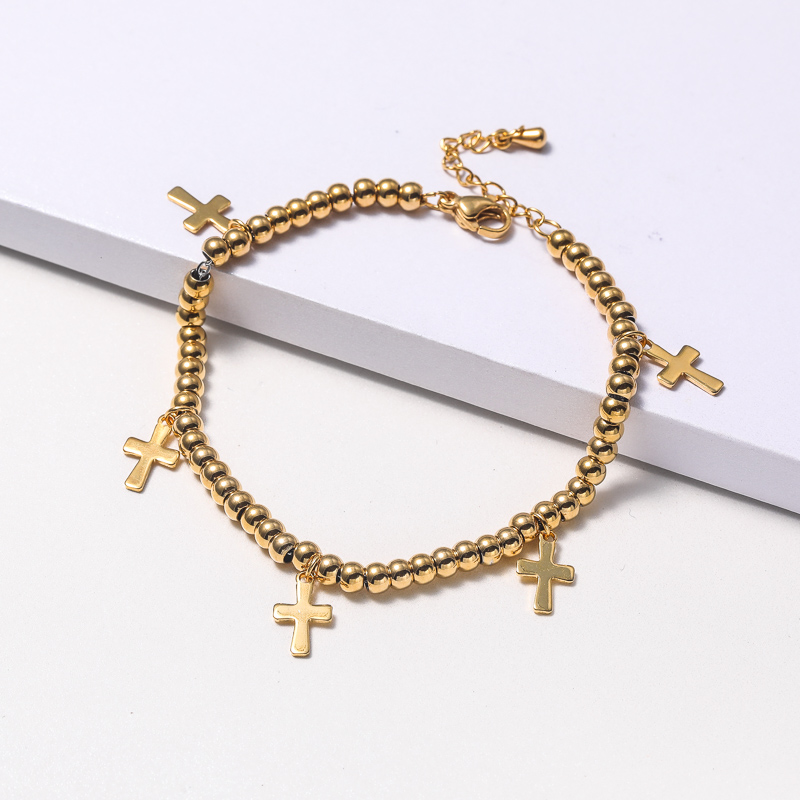 pulsera de moda dorada de bolita con dije de cruz