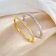 Brazalete de diamante artificial con incrustaciones de acero de titanio redondo de estilo moderno
