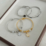Brazalete chapado en oro de 18 quilates con incrustaciones de acero de titanio y trébol de cuatro hojas elegante