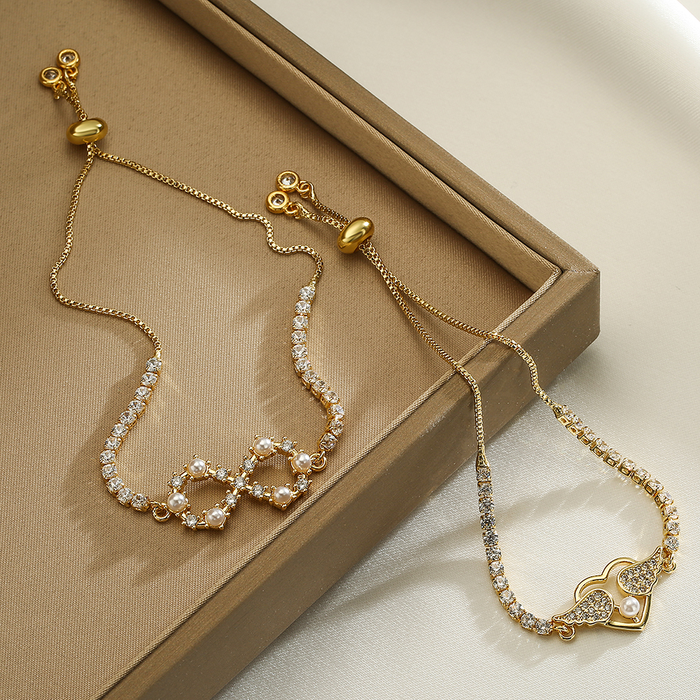 Estilo simple Infinito Alas en forma de corazón Chapado en cobre Incrustaciones de perlas artificiales Circón Pulseras chapadas en oro de 18 quilates