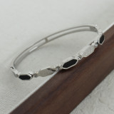 Brazalete chapado en oro de 18 quilates con incrustaciones de acero de titanio y trébol de cuatro hojas elegante