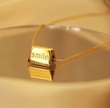 Collar chapado en oro de 18 quilates con revestimiento de acero de titanio y cara sonriente cuadrada con letras de estilo sencillo