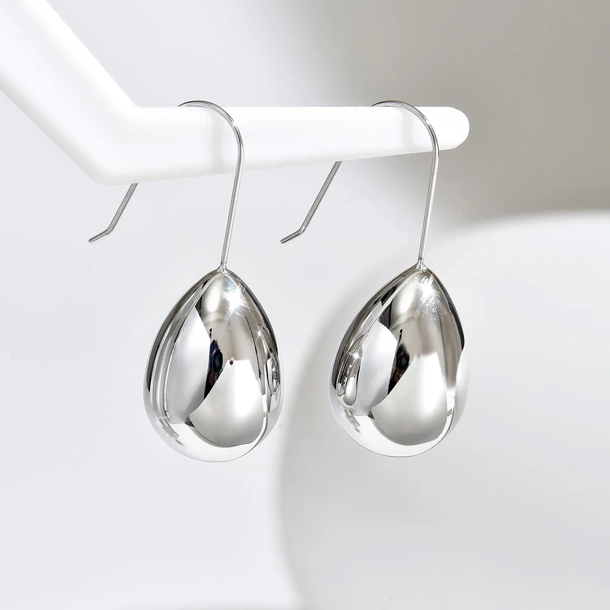 European and American minimalist niche design, face-slimming, elegant, teardrop hollow earrings for women, titanium steel cool silver egg stud earrings