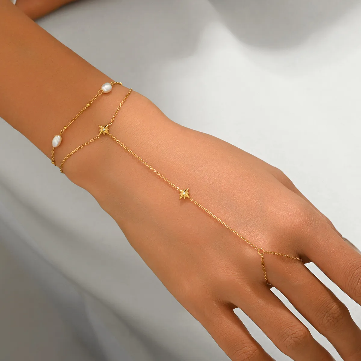 Cross-border ins light luxury gold-plated stainless steel hand chain with water drop zircon and freshwater pearl exquisite finger chain for women