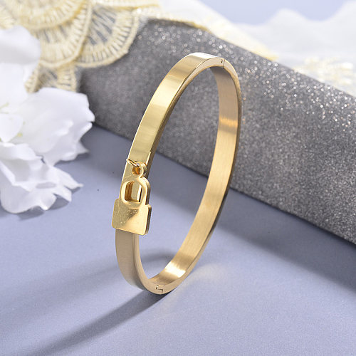 Golden stainless steel solid bracelet with small lock pendant