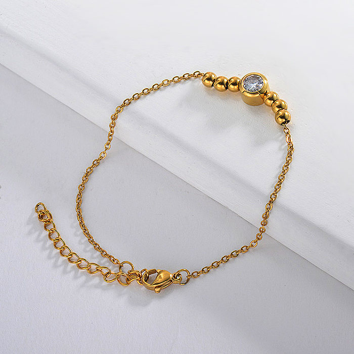 Golden stainless steel ball bracelet with white zircon pendant