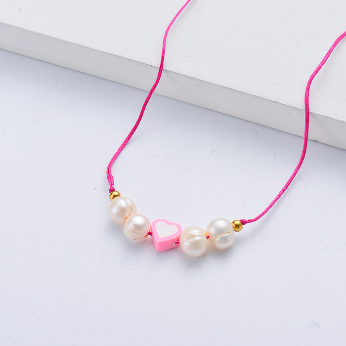 Preciosa joyería colgante de corazón rosa y blanco con collar de perlas naturales.