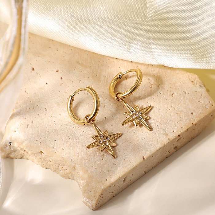 Boucles d'oreilles pendantes cinq zircons incrustées d'une étoile à huit branches en or 14 carats
