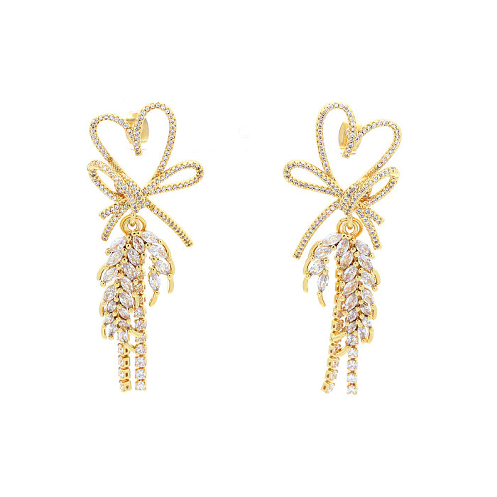 1 par de lujosos pendientes de gota chapados en oro de 18K con forma de corazón brillante y nudo de lazo con incrustaciones de borlas de cobre y circonita