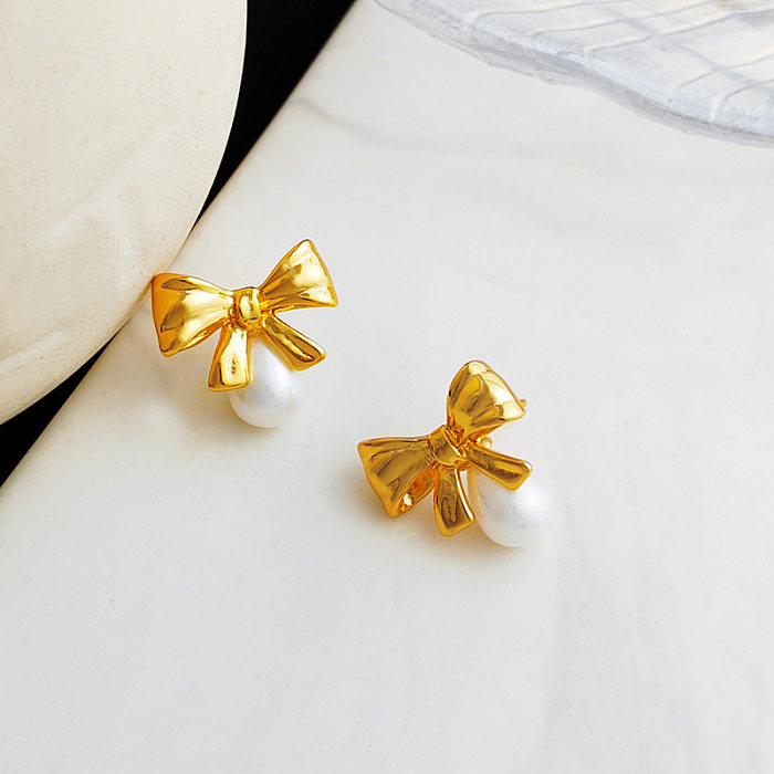 1 paire de clous d'oreilles en perles artificielles plaquées cuivre, nœud papillon doux