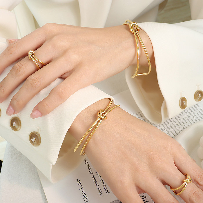 Elegante geometrische Titanstahlbeschichtung mit 18 Karat vergoldeten Ringen und Armbändern