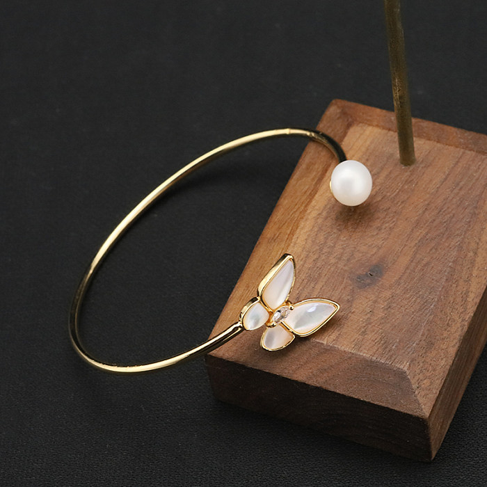 Brazalete chapado en oro de 18 quilates con circonita perla y incrustaciones de cobre y mariposa elegante