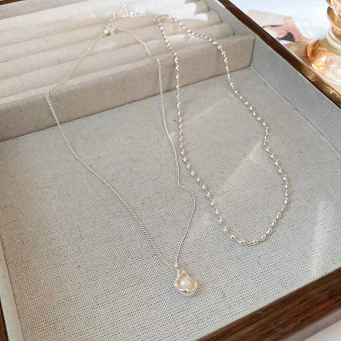 Collier élégant de perles artificielles avec incrustation de cuivre géométrique