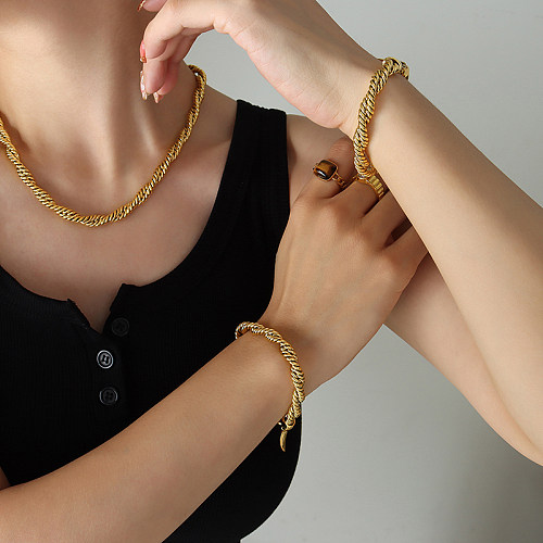Schlichte, gedrehte Halskette mit vergoldeten Armbändern aus Titanstahl