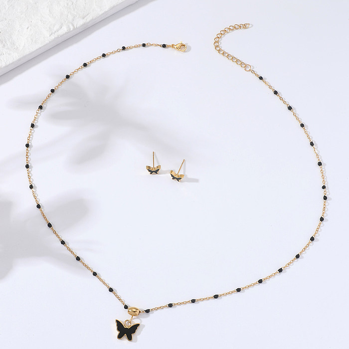 Schlichtes, mit 18 Karat Gold vergoldetes, schwarzes Emaille-Schmetterlings-Halsketten-Ohrring-Set aus Edelstahl