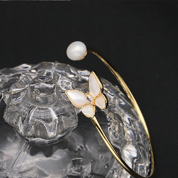 Brazalete chapado en oro de 18 quilates con circonita perla y incrustaciones de cobre y mariposa elegante