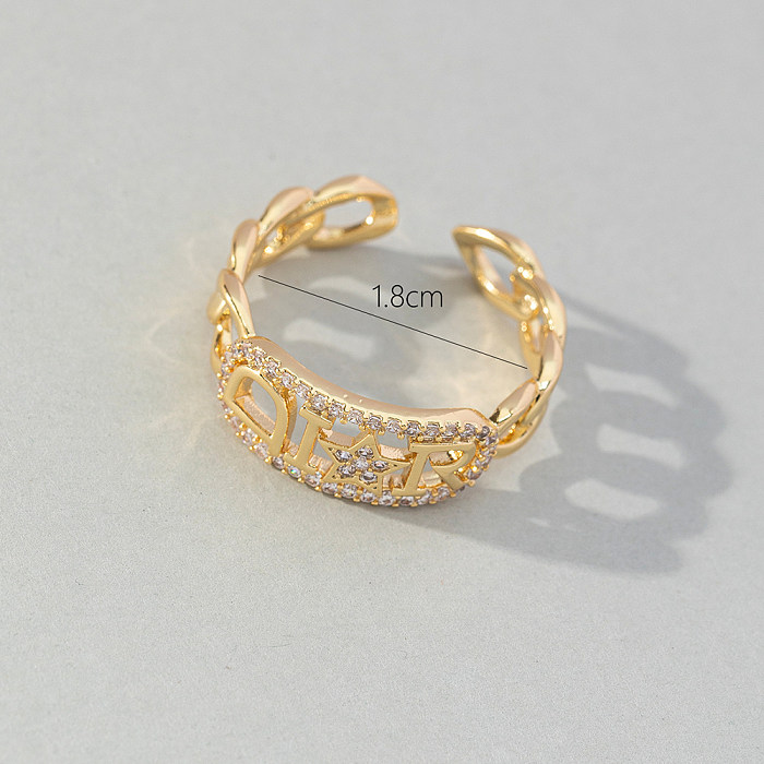 Einfacher offener Ring aus Kupfer mit Buchstaben und künstlichen Edelsteinen in großen Mengen
