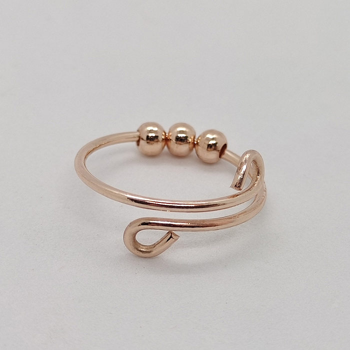 Einfacher, geometrischer offener Ring aus Edelstahl und Kupfer in loser Schüttung