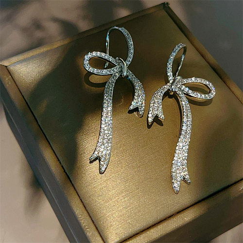 1 paire de boucles d'oreilles élégantes en cuivre et Zircon avec incrustation de nœud papillon pour dame