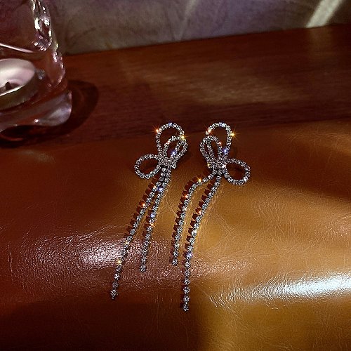 1 paire de boucles d'oreilles pendantes avec nœud papillon brillant, incrustation de strass en cuivre plaqué argent