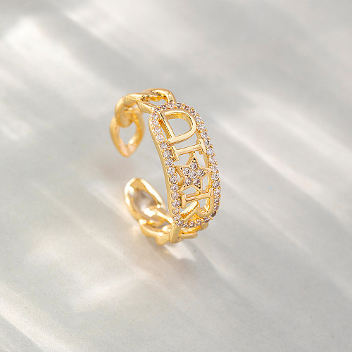 As pedras preciosas artificiais do cobre simples da letra do estilo abrem o anel no volume