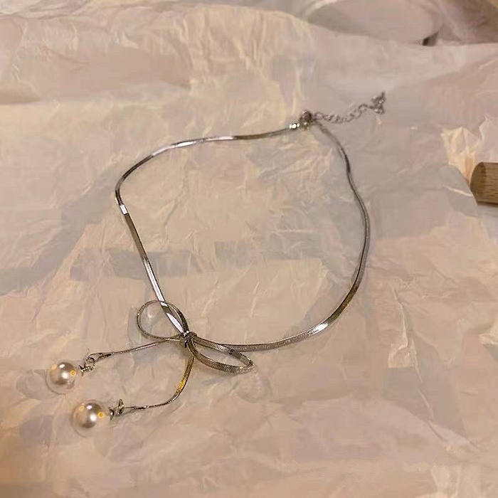Collier élégant de perles artificielles avec incrustation en acier inoxydable avec nœud papillon doux