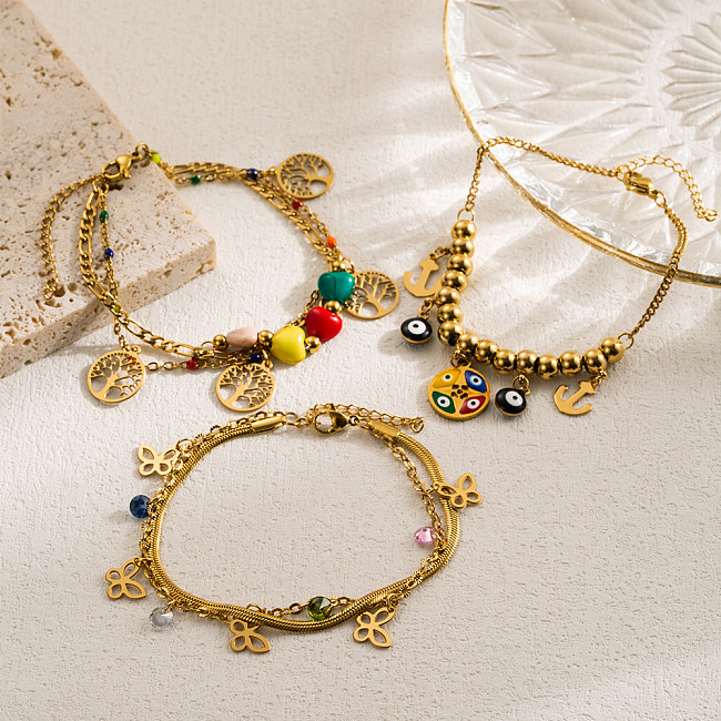 Pulseras chapadas en oro en capas de perlas de imitación de acero inoxidable con mariposa y árbol de ojo de diablo de estilo moderno informal