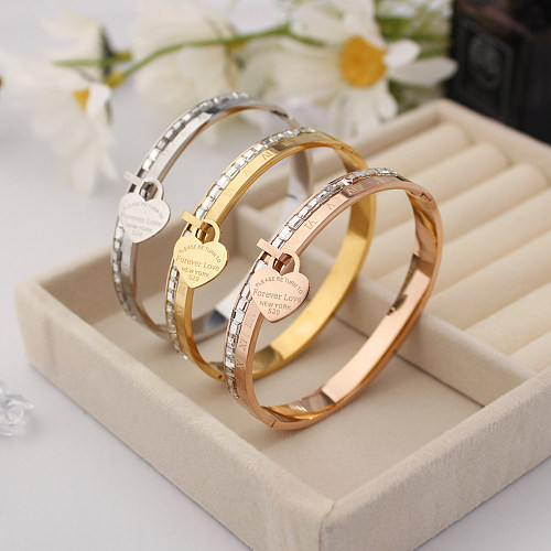 Venta al por mayor Elegante estilo simple Letra de estilo romano Forma de corazón Acero inoxidable Acero de titanio Incrustaciones de revestimiento de pulido Brazalete de diamantes de imitación chapado en oro de 18 quilates