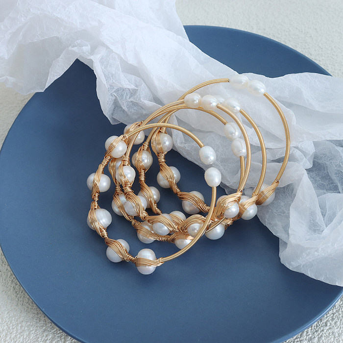 Brazalete chapado en oro de 18 quilates con incrustaciones de perlas de agua dulce y retazos de acero de titanio redondo lujoso y elegante