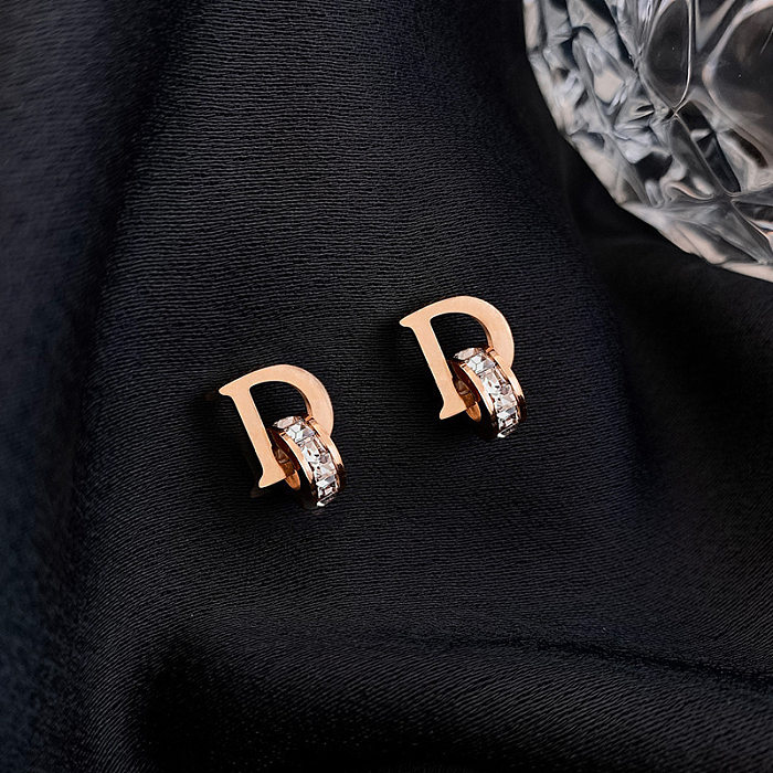 1 paire de clous d'oreilles élégants Glam Lady avec incrustation de lettres en acier inoxydable et zircon plaqué or 18 carats