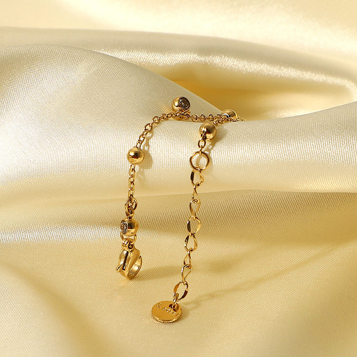 Bracelet en acier inoxydable plaqué or 14 carats avec cinq petits pompons en zircon
