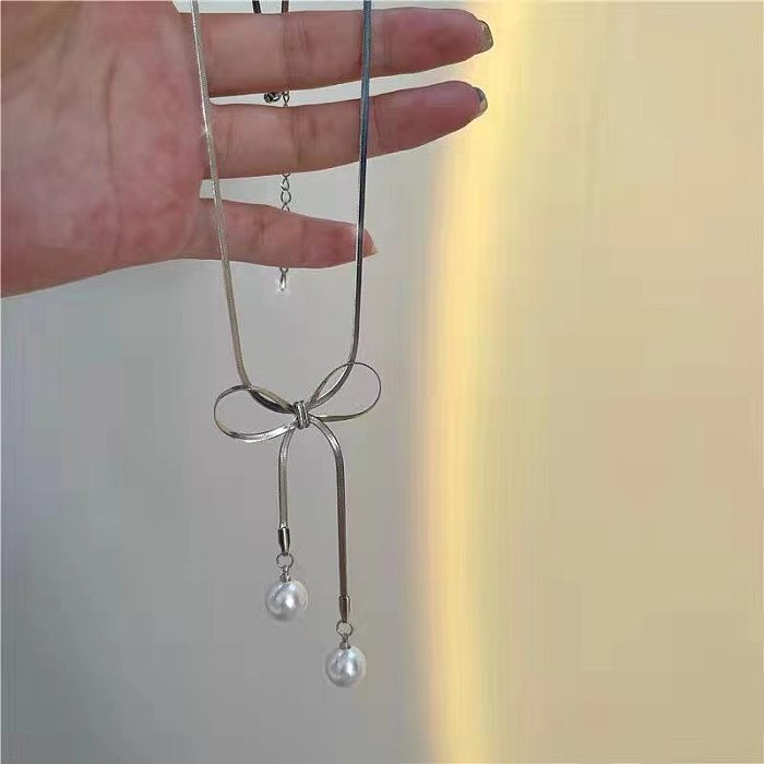 Collier élégant de perles artificielles avec incrustation en acier inoxydable avec nœud papillon doux