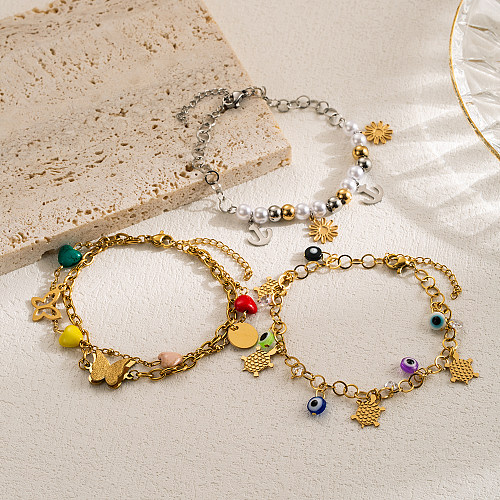 Pulseras chapadas en oro con capas de perlas de imitación de acero inoxidable y mariposa con ojo de diablo de estilo moderno