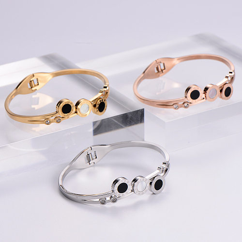 Simples concha preta e branca com algarismos romanos abrindo pulseira de aço titânio em ouro rosa