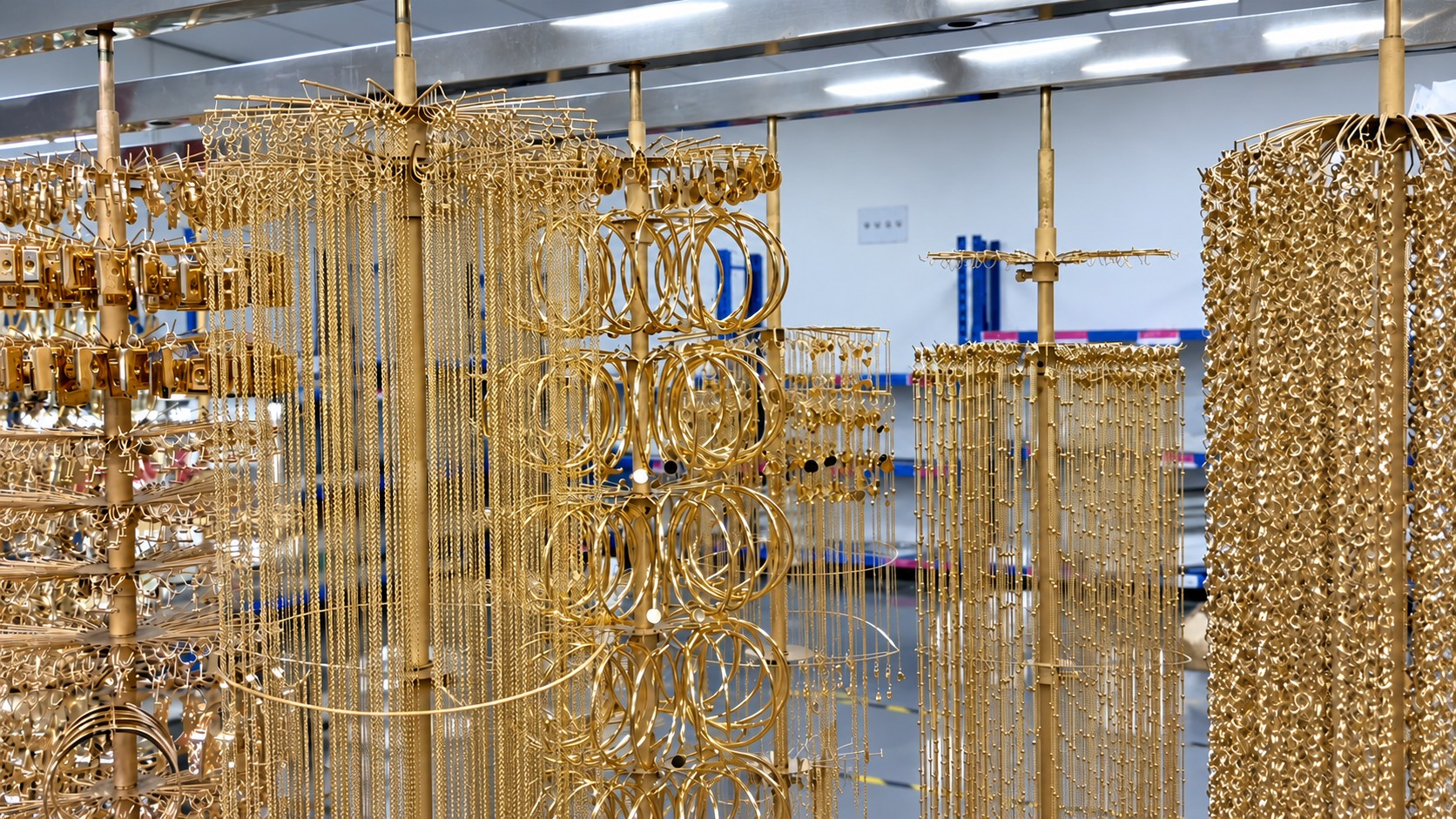 PVD gold-tone stainless steel jewelry on production racks after coating