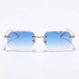 Rimless octagon sunglasses with gold metal frame and deep blue-to-clear gradient lenses front view