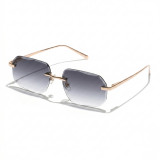 Rimless polygon sunglasses with gold metal frame and grey-to-clear gradient lenses.