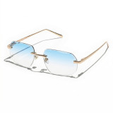 Rimless geometric sunglasses with gold metal frame and ice blue-to-clear gradient lenses