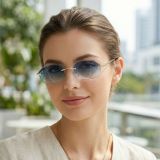Rimless octagon sunglasses with gold metal frame and deep blue-to-clear gradient lenses female model