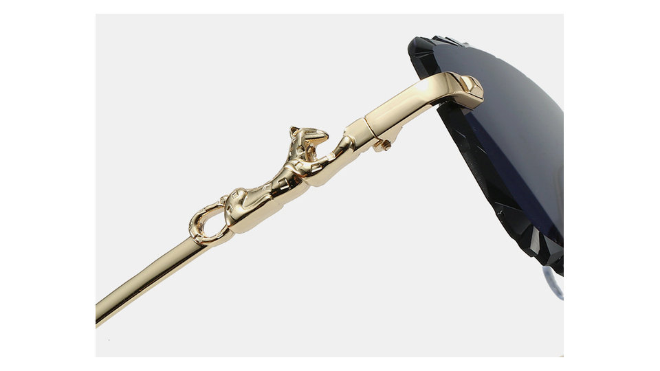 Close-up of the sculpted gold-tone panther accent beside the rimless lens