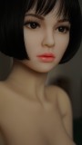 短い髪、絶妙なメイク、美しい顔の特徴を持つ人形の正面写真