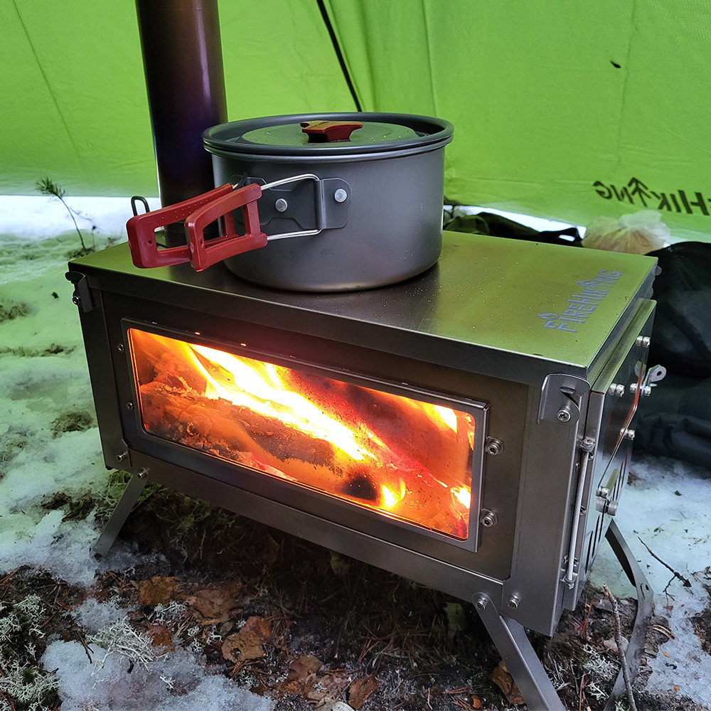 Hot tent stove in a camping tipi tent with firewood burning and cooking